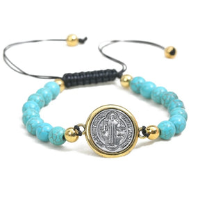 Elegant adjustable turquoise color bracelet featuring turquoise beads and a gold-toned Saint Benedict medal on a durable black cord.