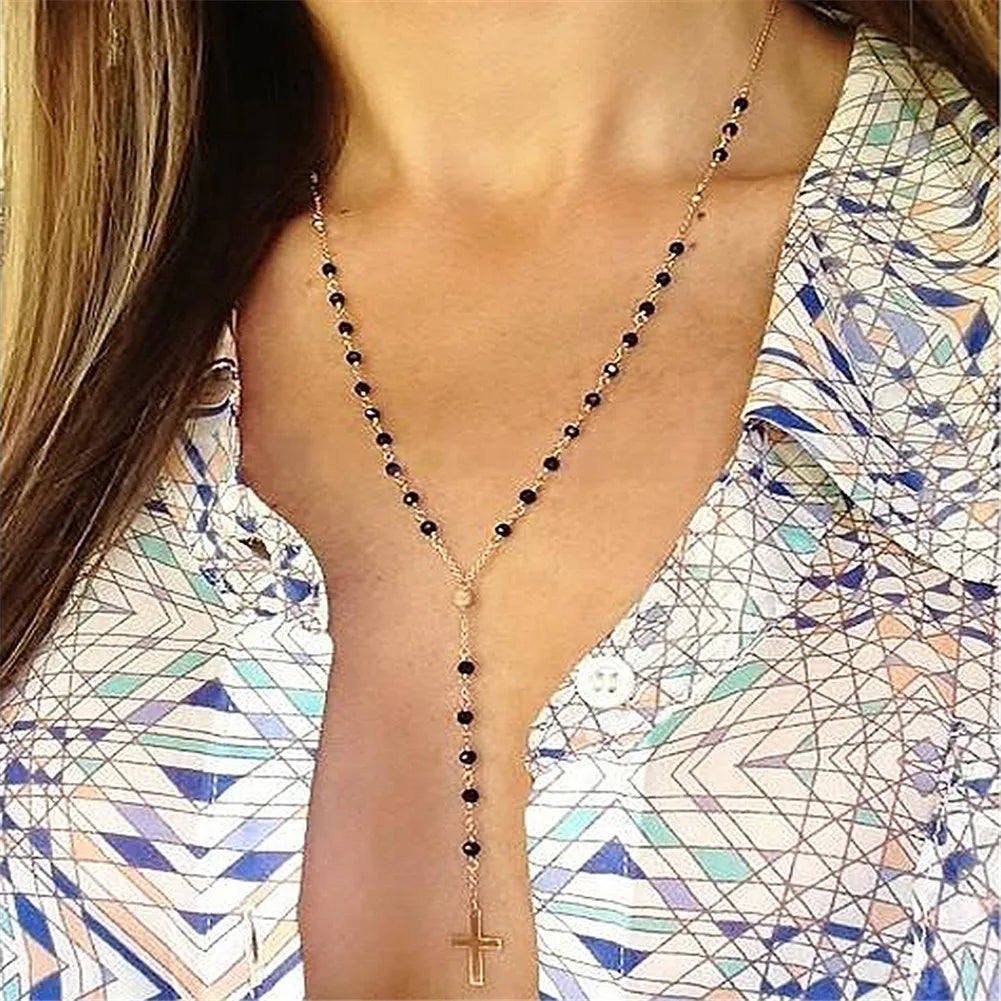 Gold-plated stainless steel rosary necklace featuring dark beads, a Y-shaped chain leading to a crucifix pendant, offering a sophisticated and spiritual design.