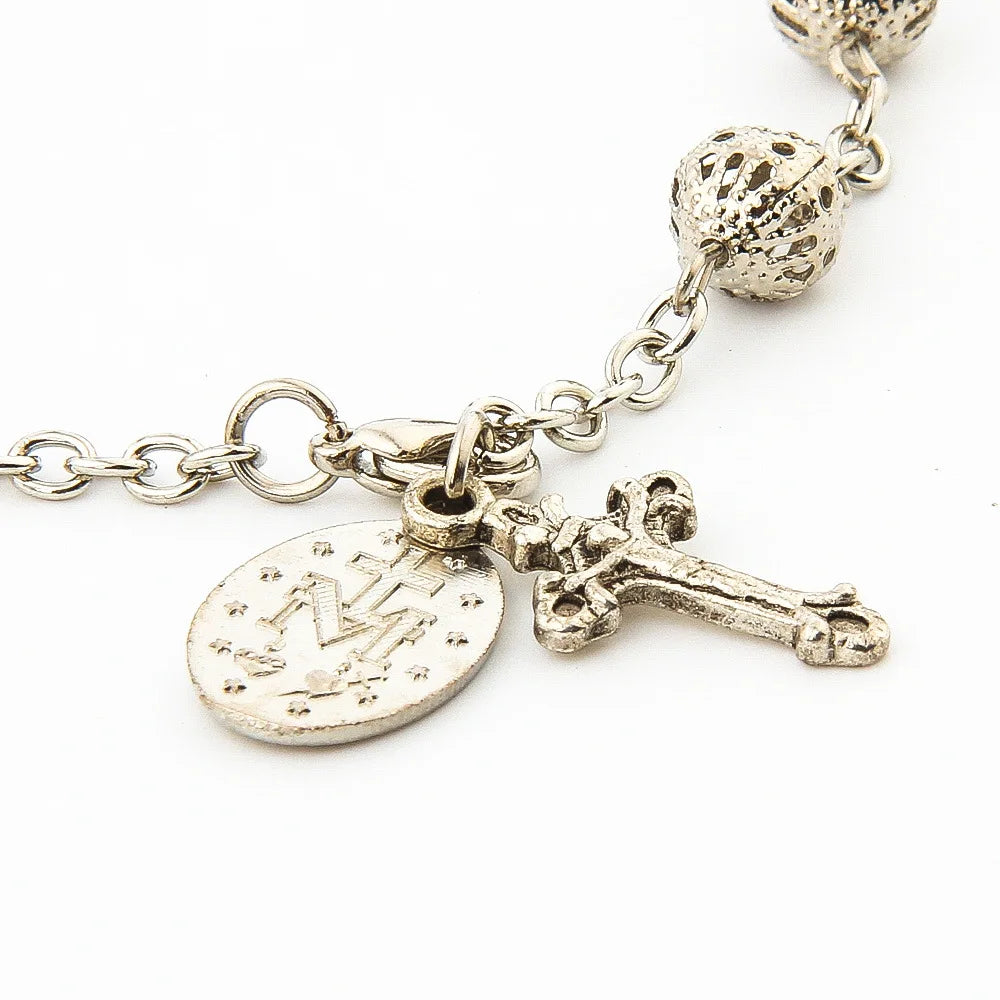 Silver - plated rosary bracelet with hollow beads, a cross pendant, and an Our Lady of Guadalupe medal.