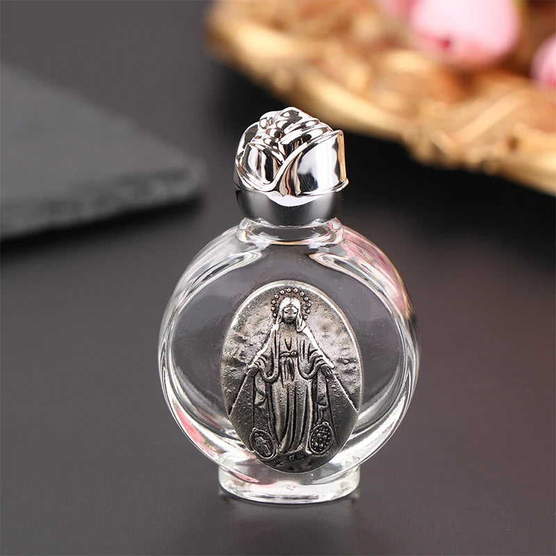 Glass holy water bottle with a silver Our Lady of Guadalupe medallion and a rose-shaped twist-on lid. Use for: Baptism, First Communion, Holy Communion, Confirmation, Blessing of Homes, Blessing of Objects, Personal Devotion, Sacramentals, Church Entrances, Funerals, Easter Vigil, Special Feast Days, Easter, Weddings, Christmas.