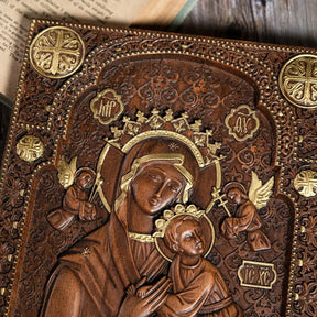 Hand-carved wooden wall decor featuring Our Lady of Perpetual Help with intricate details and gold highlights, perfect for home or church.