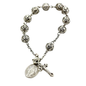 Silver - plated rosary bracelet with hollow beads, a cross pendant, and an Our Lady of Guadalupe medal.