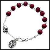 Vintage-style bracelet featuring dark red scented wooden beads and a silver St. Mary pendant on a chain, perfect for spiritual expression and fashion.